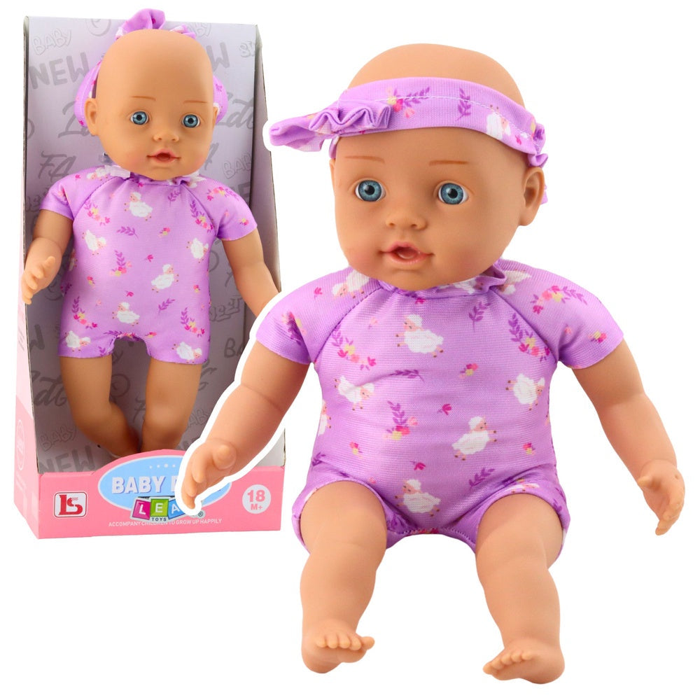 Babydocka 31 cm med lila bodysuit och huvudband